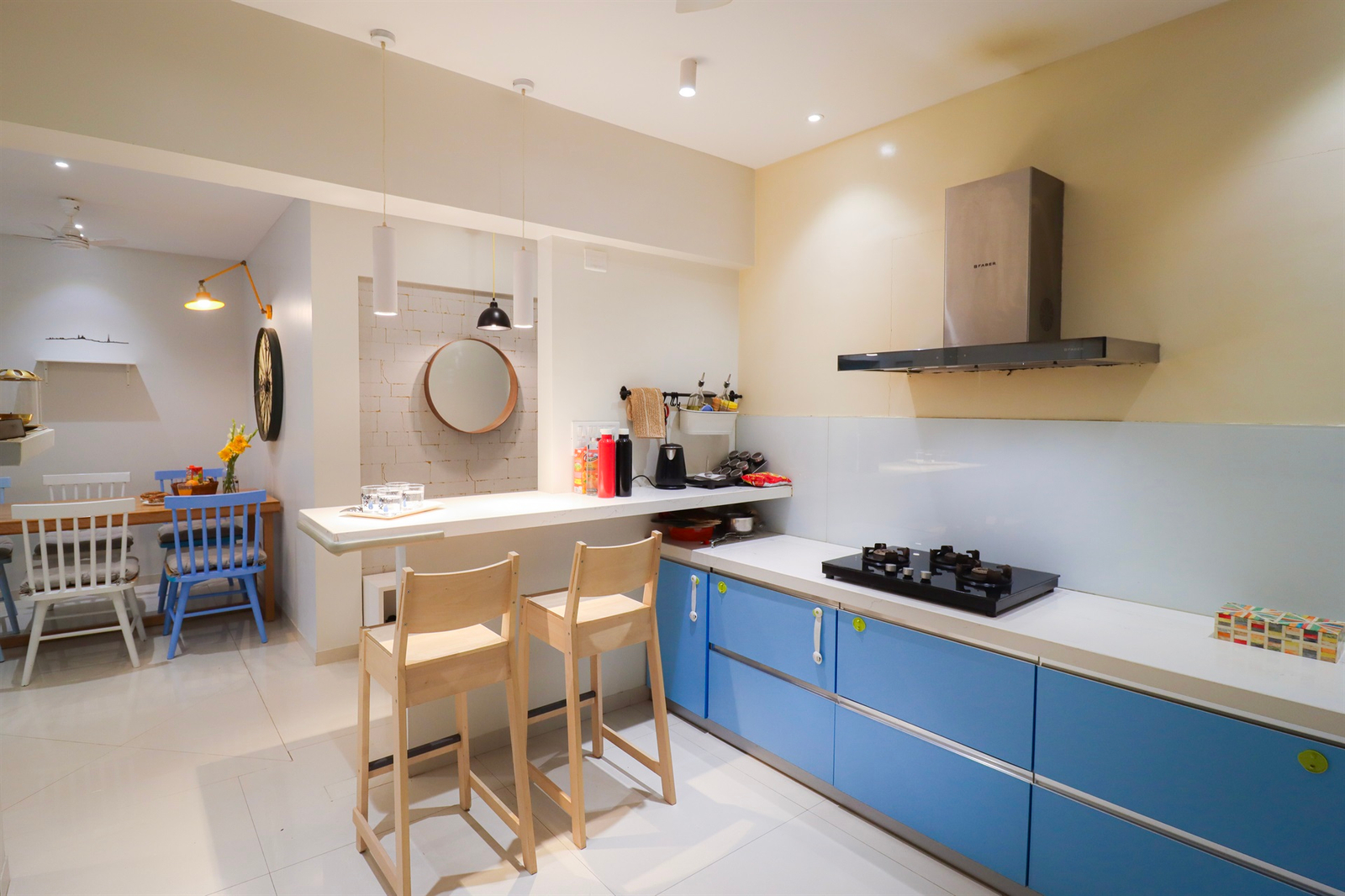 a kitchen with blue cabinets and chairs